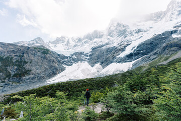 A female hiker stands in the French valley with mountains on the background, Torres del Paine National Park, Chile