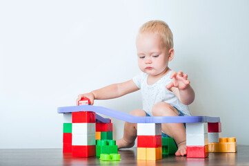 Toddler boy plays with constructor, cars, blocks close-up. Educational toys for preschool children...