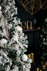 Christmas tree in the interior of the living room of a residential building in black and gold colors. festive atmosphere before Christmas. holiday card