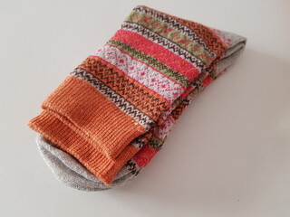 Pair of new warm winter socks with a beautiful pattern on a white table