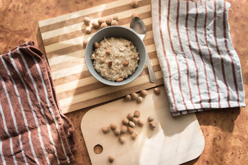 Healthy, dietary and nutritious oatmeal with hazelnuts in a gray plate on the table top view.