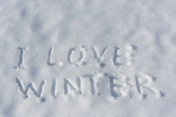 Inscription I love winter, written on white surface of the snow . Top view. Flat lay. Winter holiday.