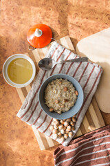 Healthy, dietary and nutritious oatmeal with delicious homemade honey, hazelnuts in a gray plate on the table top view.