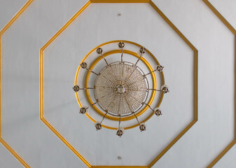 A luxury glass ceiling light with  golden border on a white ceiling