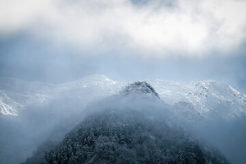 Snow-capped mountain peak emerging from the mist