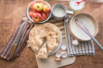 Homemade and puffed apple biscuit and sliced ​​pie in a saucer on the table.