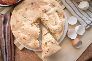 Homemade and puffed apple biscuit and sliced ​​pie in a saucer on the table.