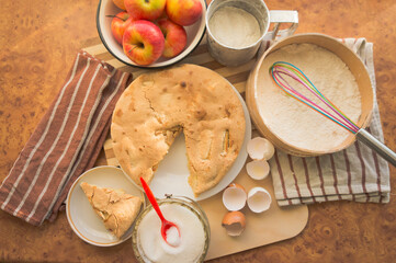 Homemade and puffed apple biscuit and sliced ​​pie in a saucer on the table.