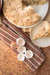 Homemade and puffed apple biscuit and sliced ​​pie in a saucer on the table.
