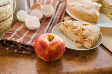 Homemade and puffed apple biscuit and sliced ​​pie in a saucer on the table.