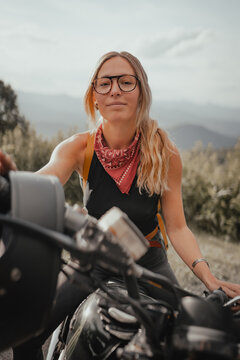 A young woman on a motorcycle in the mountains