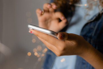 hands of a girl holding a smartphone closeup. girl communicates online on social networks. blogger. space for text. High quality photo