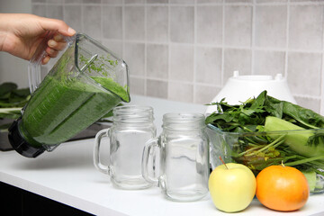 Serve green juice in mason jar just made in kitchen blender with ingredients like cucumber, chard, spinach, celery for a nutritious breakfast
