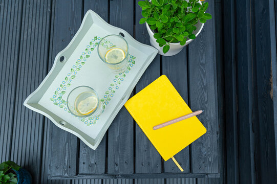 Flay lay with a yellow book for copy space on garden wooden black furniture background.