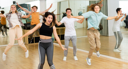 Group of happy teens jumping during exercising in choreography class