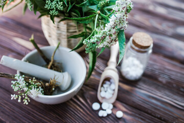 Valerian tablets with sedative properties. Pharmaceutical jar with pills on a wooden table. Cooking...
