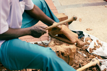 African craftsman works on the city street.