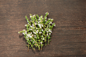 White flowers of mountain thyme on a worn wooden surface