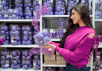 Girl in sweater buying Christmas ornaments 