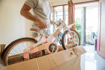 A man unboxing and removing a mini bike