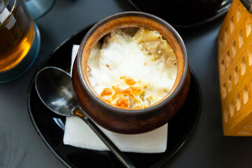 Russian dish - baked dumplings with cream in a pot