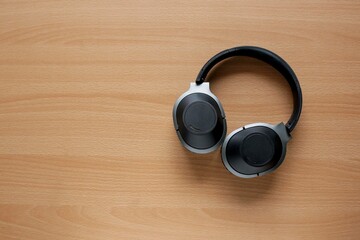 View from above of a black headphones on the wooden table 