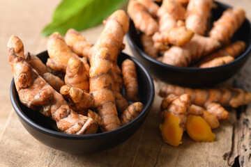 Fresh turmeric in a bowl on wooden background, Food ingredients in Asian food and used in beauty spa and herbal medicine