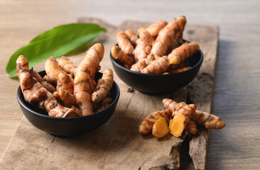Fresh turmeric in a bowl on wooden background, Food ingredients in Asian food and used in beauty spa and herbal medicine