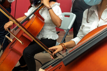 Hispanic girl having music lessons of cello during coronavirus pandemic. © Carlos