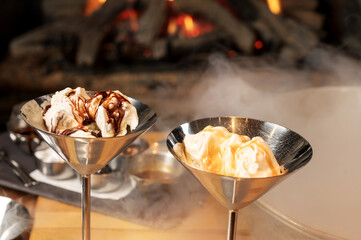 Hand made ice cream with steaming liquid nitrogen with a fire place in the background.