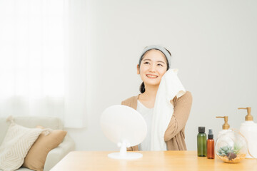タオルで顔を拭く女性
