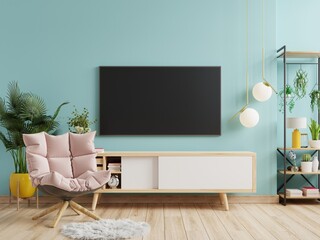 Mockup a TV wall mounted with armchair in a living room with a blue wall.