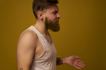 Cheerful bearded man in a white T-shirt with hooligan tattoos on his arms