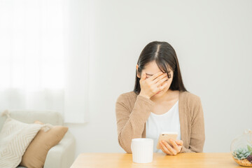 スマホを見てショックを受ける女性
