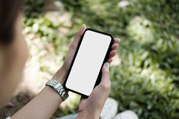 Top view mockup image of a woman holding a black mobile phone outdoor garden