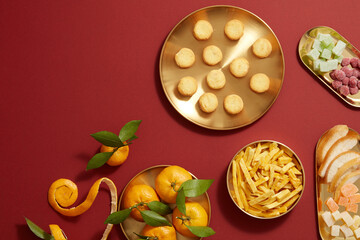 Tet holiday with mandarin orange candy jam , fried potato , flower and ang pao biscuit in golden dish , red background photography Tet holiday content , chinese new year