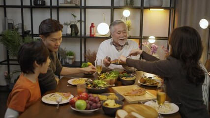 Happy Asian family gathering around the dining table and enjoy dinner.