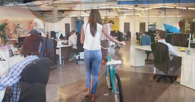 Animation of hands using laptop, over colleagues at creative office with bike and on hoverboard