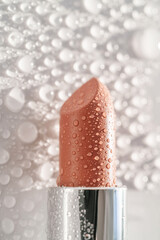 Moisturizing lipstick with water drops on it.