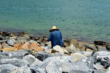 Fisherman preparing to fish on rock seawall in Cape Canaveral