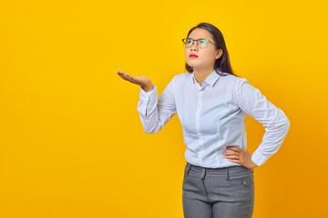 Photo of shocked young business woman with confused and displeased expression on yellow background