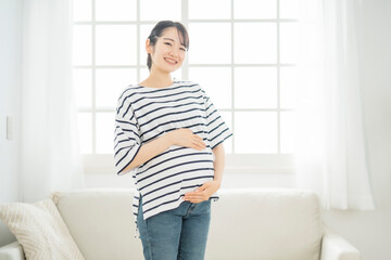 部屋にいる妊婦（笑顔・カメラ目線）
