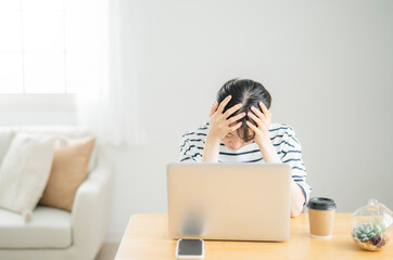 パソコンを使いながら落ち込む女性
