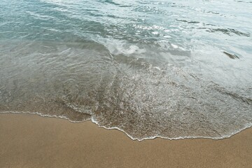 Soft wave of blue sea on sandy beach. texture Background.