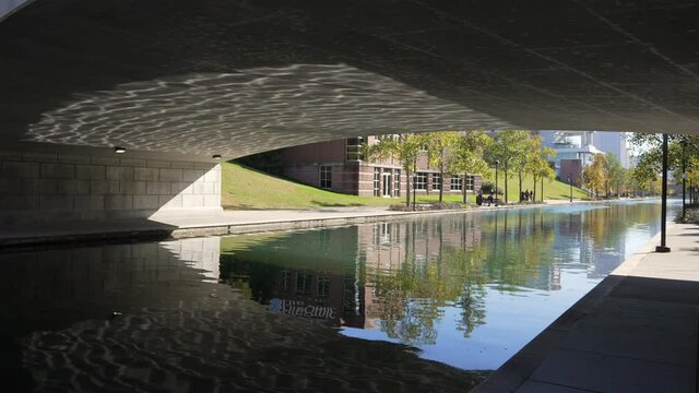 This video features the reflecting of water rippling on the underside of a beautiful canal bridge.