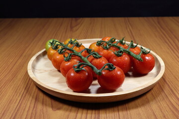 Pile of fresh Japanese tomato on the wooden plate. Famous organic fruit in Asia.
