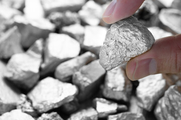 Miners hold in their hands platinum or silver or rare earth minerals found in the mine for...