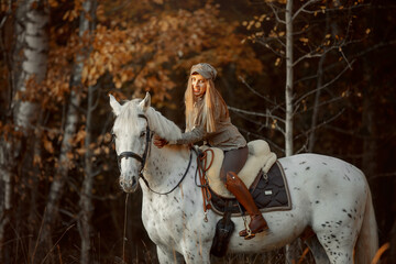 Beautiful young woman in English hunter wear style with Knabstrupper horse and Irish setter at autumn park - 469624439