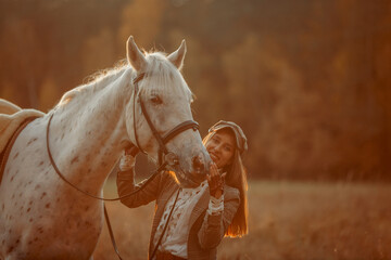 Beautiful young woman in English hunter wear style with Knabstrupper horse and Irish setter at autumn park - 469624467