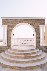 Arched balcony with balustrade and steps overlooking the Lustica bay. Montenegro